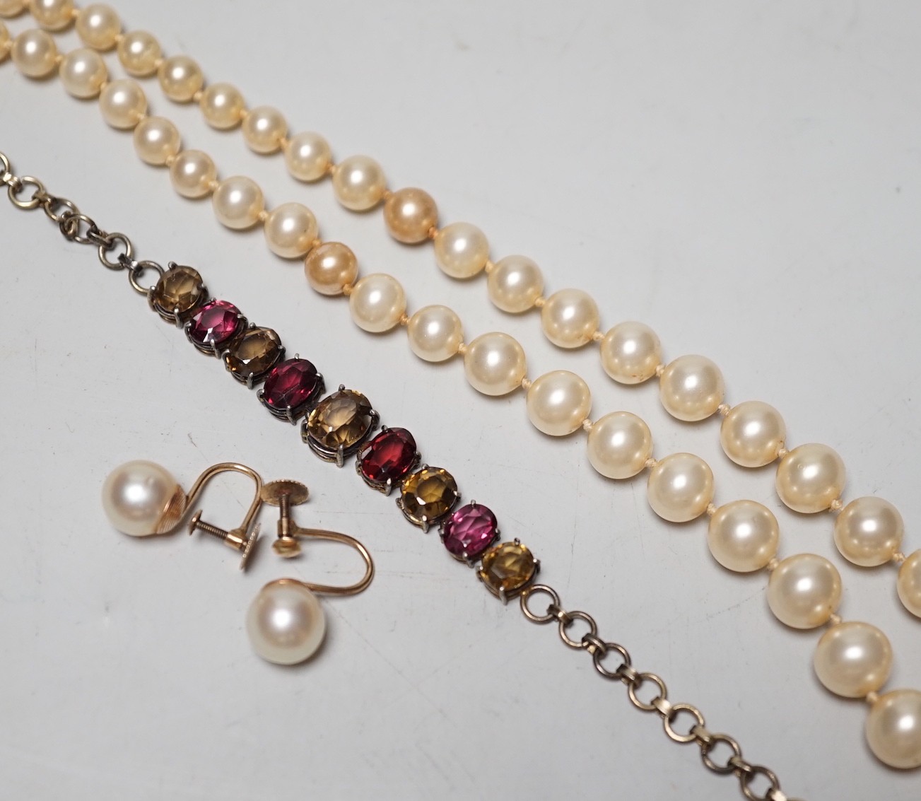 A gilt metal and coloured paste set bracelet, a pair of 9ct and cultured pearl set ear clips and a simulated pearl necklace, with 9ct clasp.